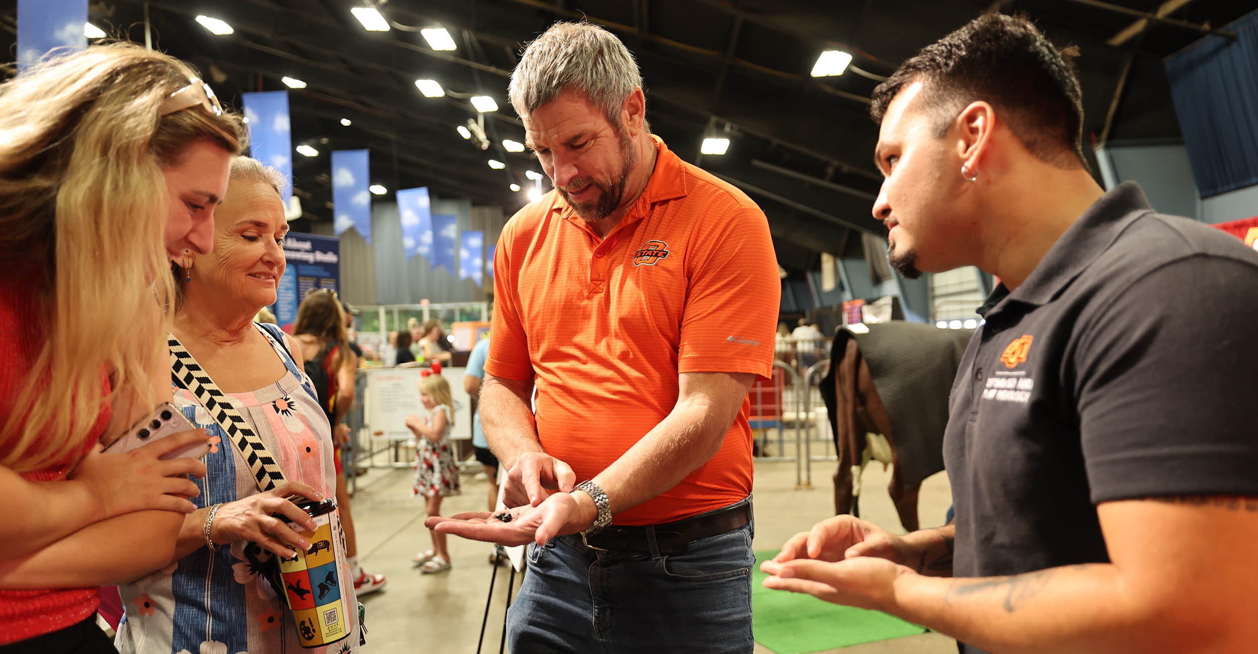 Wyatt Hoback and Rodrigo Soares talk to fair attendees about their sung beetle research at the Oklahoma State Fair.
