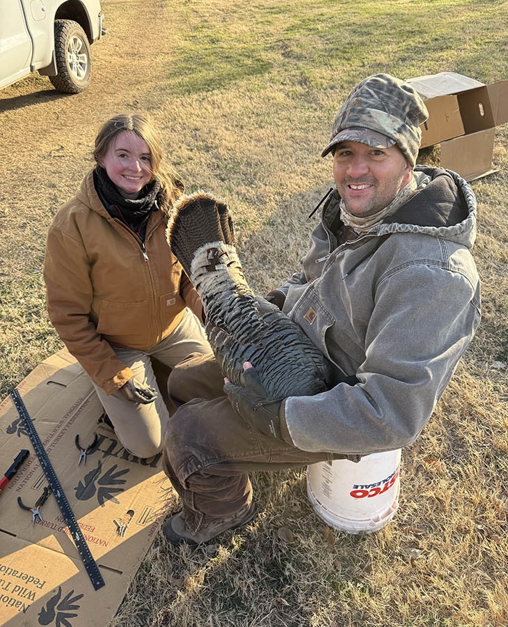Colter Chitwood and his student, Lydia Laughlin, posing while holding a wild turkey during their in-field research.